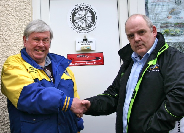 Dr David Stevens MBE shakes hands with Dr Gruff Evans whose Manx Roadracing Medical Services will take over from Dr Stevens who has provided medical cover for Manx motorsport events for nearly forty years