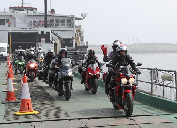 Riders and their passengers stream of the Isle of Man Steam Packet Company's high speed vessel 'Manannan' in Douglas harbour during TT 2019