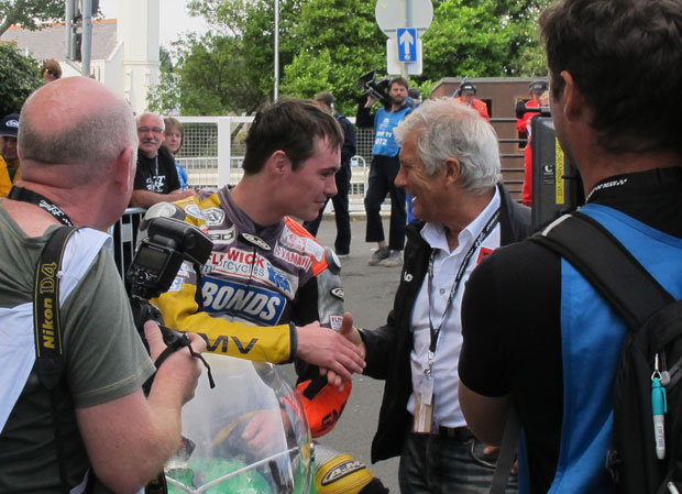 Press watch on as 15-time world champion Giacomo Agostini congratulates Olie Linsdell