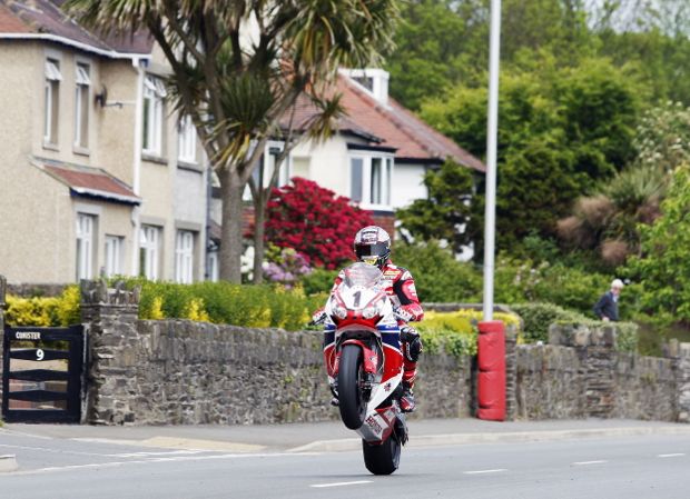 Always the crowd pleaser; John McGuinness pulls a big wheelie