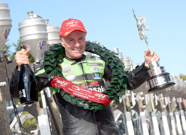 Ian Lougher holding the winner's trophy after winning the 2014 500cc Classic TT
