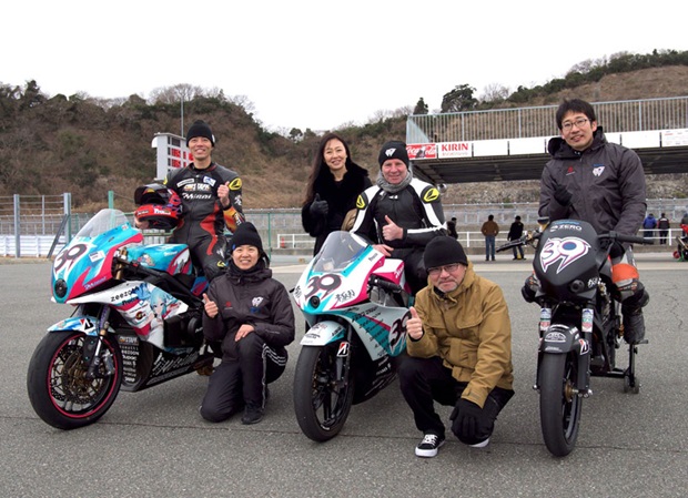 Photocaption:  Ian Lougher with his wife Asa at the recent TEAM MIRAI test session in Japan.  Included aer Yoshihiro Kishimoto and his wife Akiko (on bike) and Kazuo Aoshima and Tomohiro Yamauchi.  The bikes are the TT Zero 13 Kai, the Idaten- zero and the Idaten-FXS.